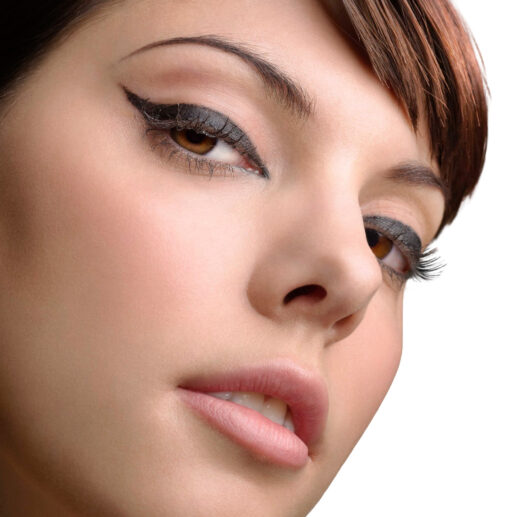 Close-up of a woman with winged eyeliner and light makeup.