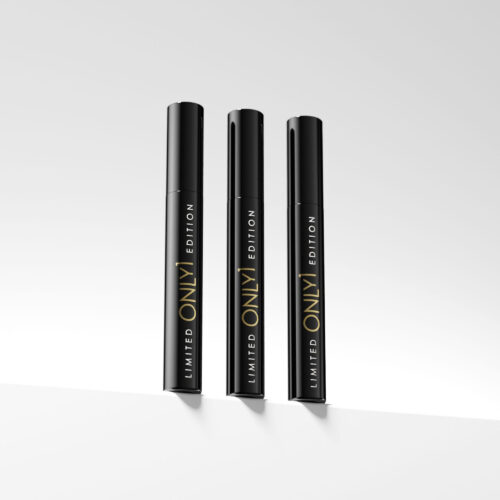 Three limited edition black mascara tubes standing upright on a plain white surface, with a minimalist background.