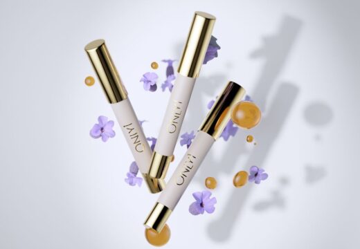Vitamin C Lip Therapy tubes with gold caps, surrounded by purple flowers and serum drops.