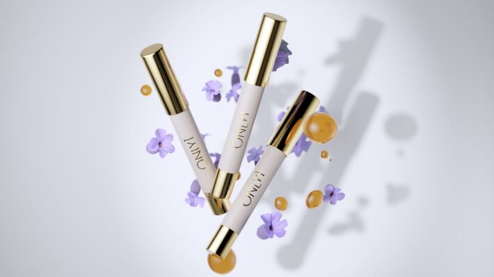 Vitamin C Lip Therapy tubes with gold caps, surrounded by purple flowers and serum drops.